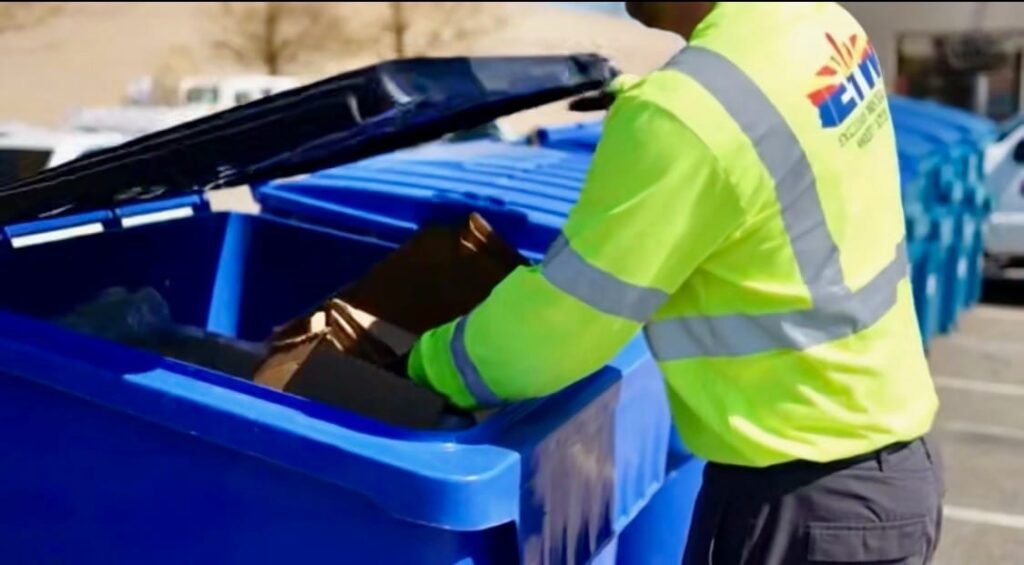 An EIW team member assisting with a residential trash bin